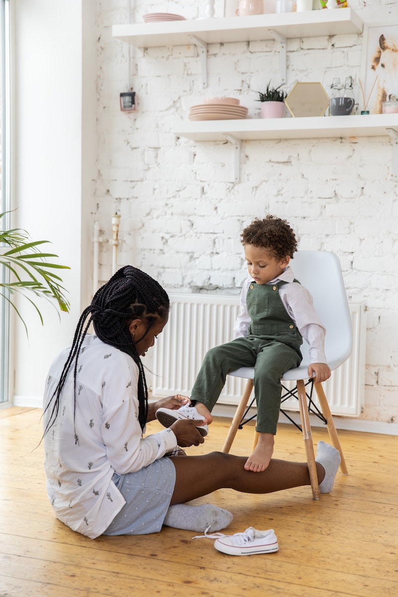 Mom putting shoes on kid