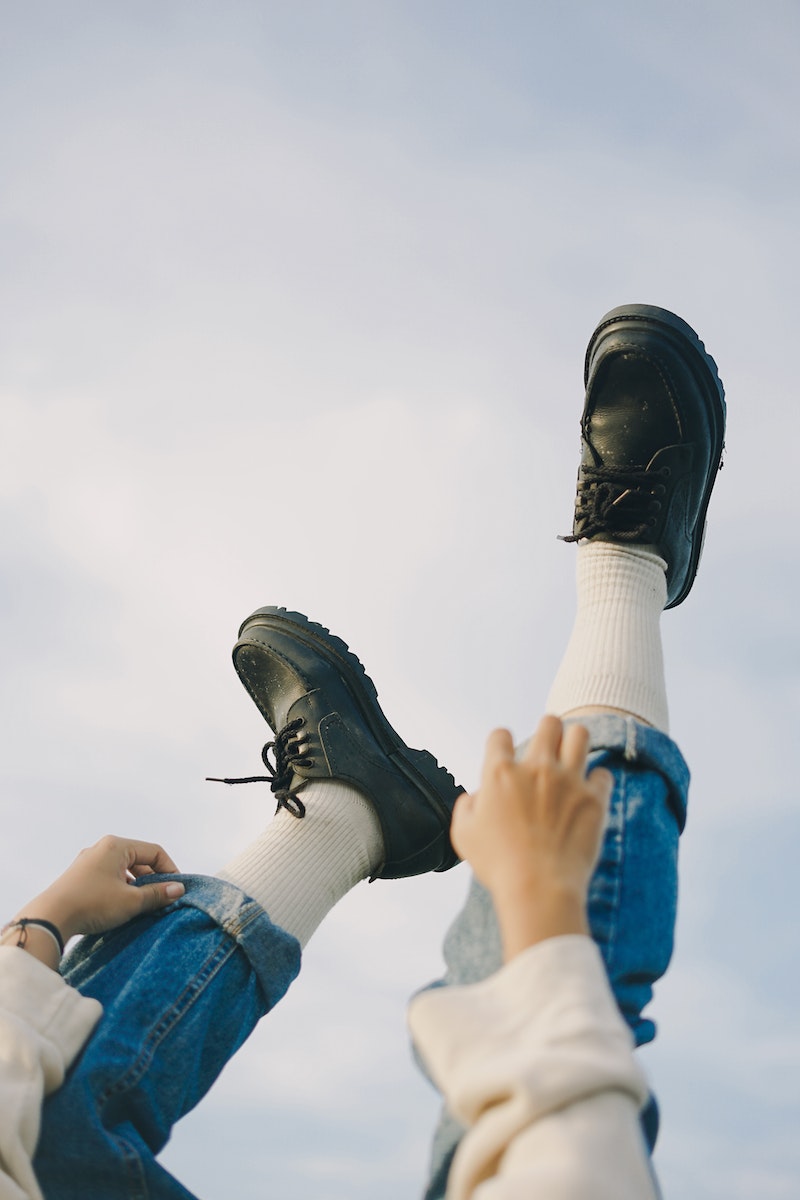 Person wearing black used leather shoes