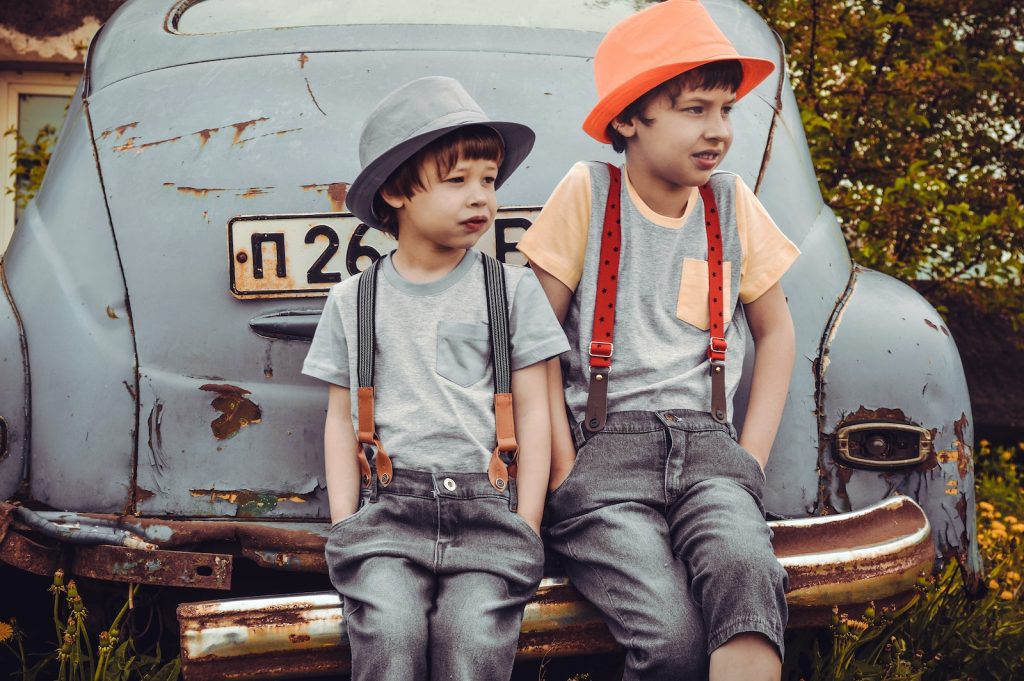 2 kids sitting on a car