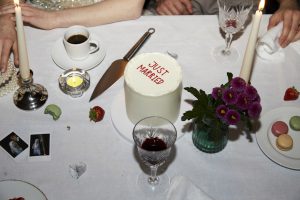 "Just Married" Hochzeitstorte an einem urordentlichen Tisch